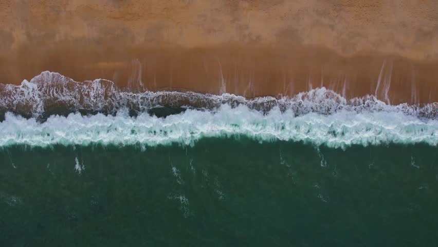 Rhythmic Ocean Waves on Nazaré's Golden Shore, Portugal