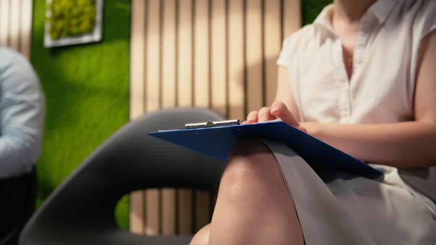 Close up of impatient nervous woman shaking her legs in queue outside HR office, repeating speech and qualifications on the CV. Preparing to impress for selection and hiring process. Camera A.