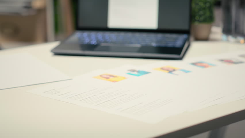 Modern desk with laptop in empty office shows applicant CV before hiring interview, office used for the recruitment process and reviewing qualifications or work experience to align with position.