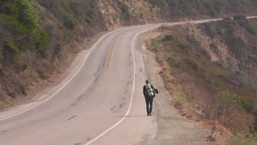 HD Footage of a Hobo Walking Along the Legendary Highway 101 Through the Big Sur Mountains