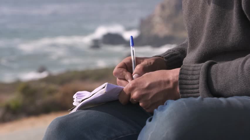HD footage capturing a hobo writing during a stop as he is traveling on the legendary Highway 101 as it winds through the dramatic Big Sur mountains in California.
