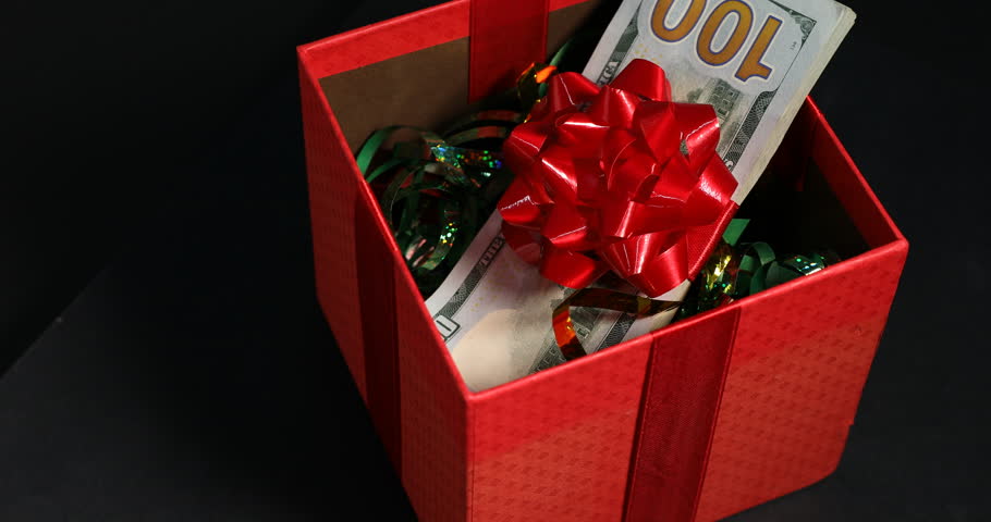 Gift box with dollar banknotes on black background, closeup