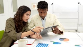 Diverse business team analyzing graphs and financial data on a clipboard during a productive meeting, demonstrating teamwork and strategic planning while discussing the company's project report - Powered by Shutterstock - Get 15% off with code: PIKWIZARD15