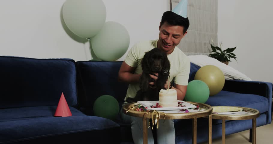 Man feeding dog cake on sofa at tech demo, sparking animated wifi cloud, location icons emerging. Celebration, companionship, digital connectivity, festive, joy, home environment, social interaction