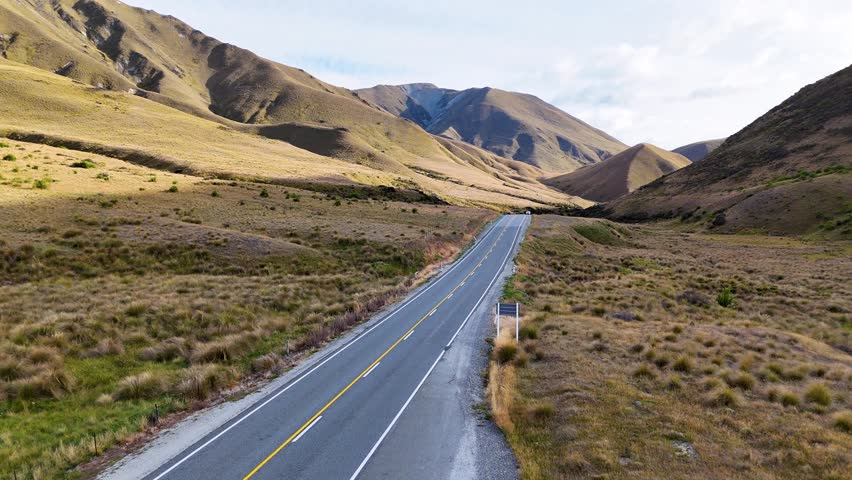 4K drone captures cars driving through Lindis Pass in New Zealand’s South Island. Winding roads, rolling hills, and mountains create a stunning alpine driving experience. - Powered by Shutterstock - Get 15% off with code: PIKWIZARD15