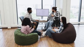 Multiracial team discussing project ideas in office, including man wheelchair, in bright space - Powered by Shutterstock - Get 15% off with code: PIKWIZARD15