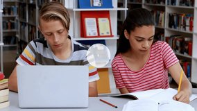 Teen students taking notes in library watching user icon appearing above laptop building network. Collaboration, technology, education, connectivity, digital, innovation, focus - Powered by Shutterstock - Get 15% off with code: PIKWIZARD15