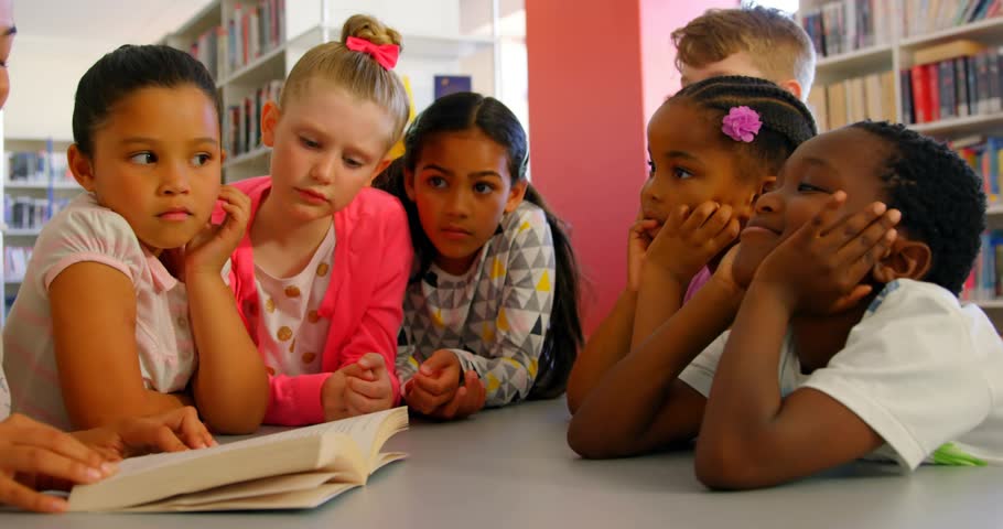 Six children sitting library table studying book, math icons appearing above page, teacher guiding. Educational, collaborative, literacy, learning, academic, inspiration, creativity