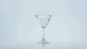 Gold confetti swirling revealing glass, olive skewer dropping causing splash, celebrating cocktail. Festive, celebration, luxury, elegance, minimalism, glamour, sophistication - Powered by Shutterstock - Get 15% off with code: PIKWIZARD15