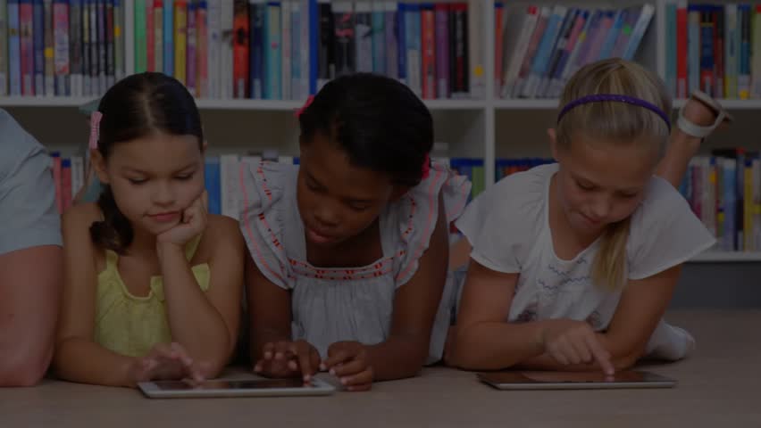 Instructor guiding children via tablet tapping in library education animating panels and charts. Collaboration, technology, innovation, education, learning, teamwork, digital