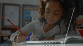 Girl writing notebook switching pen and generating network graphics over laptop in classroom. Education, technology, innovation, childhood, connectivity, learning, digital - Powered by Shutterstock - Get 15% off with code: PIKWIZARD15