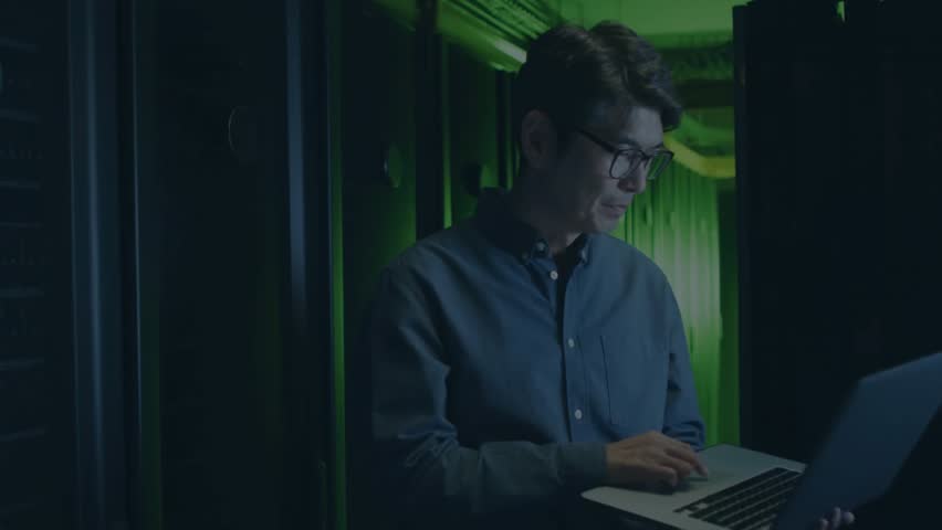 IT specialist typing on laptop in server room, glitch lines generating encryption overlays. Technology, cybersecurity, digital, innovation, futuristic, professional, data - Powered by Shutterstock - Get 15% off with code: PIKWIZARD15