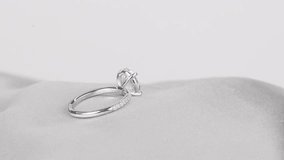 Sparkling diamond ring displayed on smooth satin fabric. - Powered by Shutterstock - Get 15% off with code: PIKWIZARD15