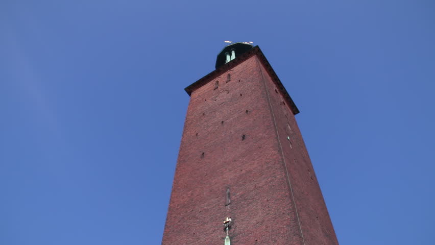 Tall red brick tower in Stockholm under clear blue sky