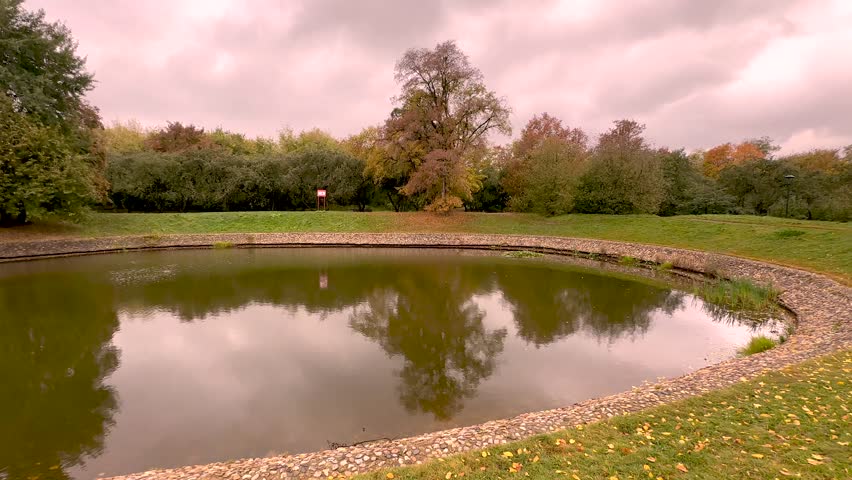 Panorama of an autumn pond and heavy clouds (4K60)