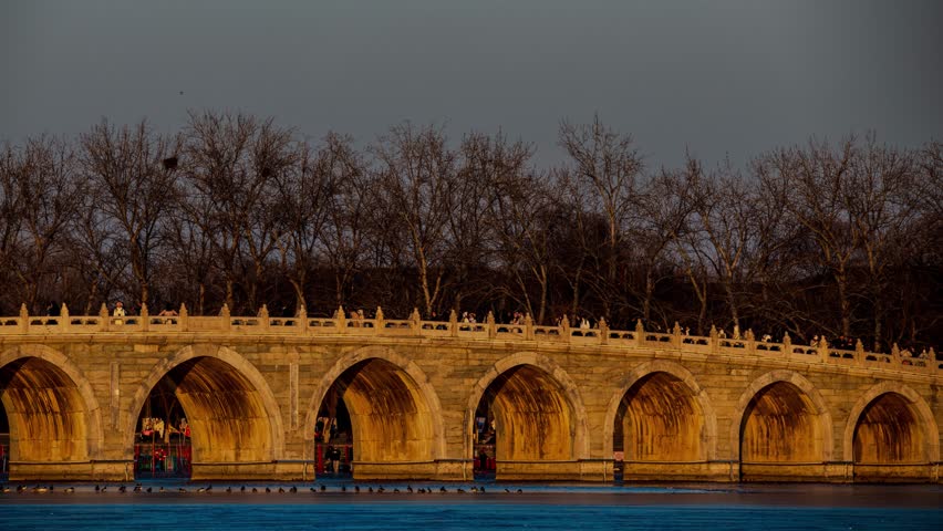 Golden hour illuminates the historic Seventeen Arch Bridge in Beijing
