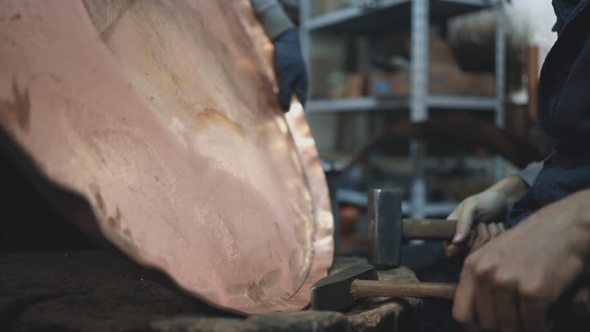 Traditional coppersmith workshop for copper brewing pots manufacturing. This handmade brewery kettles will be used for making traditional alcohol brandy drinks. Small traditional business concept.