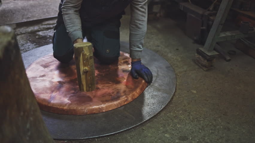 Traditional coppersmith workshop for copper brewing pots manufacturing. This handmade brewery kettles will be used for making traditional alcohol brandy drinks. Small traditional business concept.