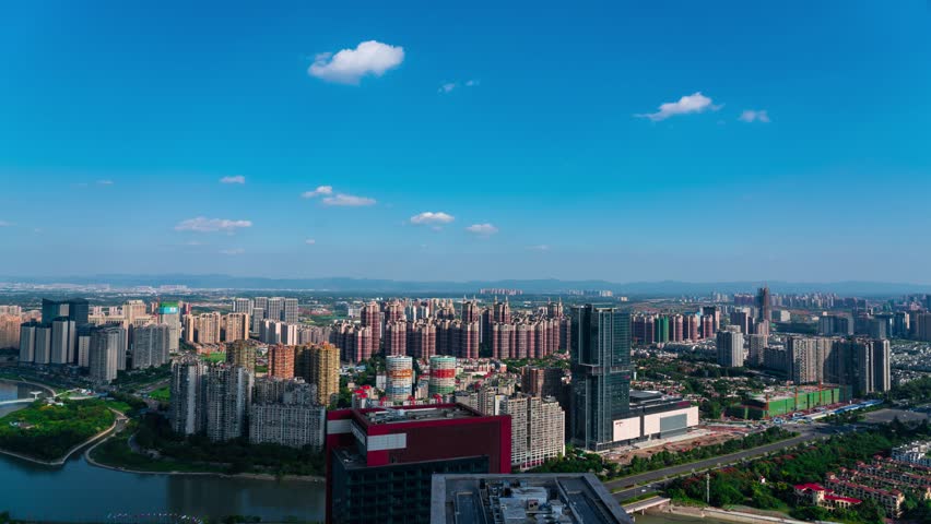 Aerial view of modern Chengdu Tianfu district showing high-rise residential buildings, commercial developments and urban landscape under blue sky with white clouds.