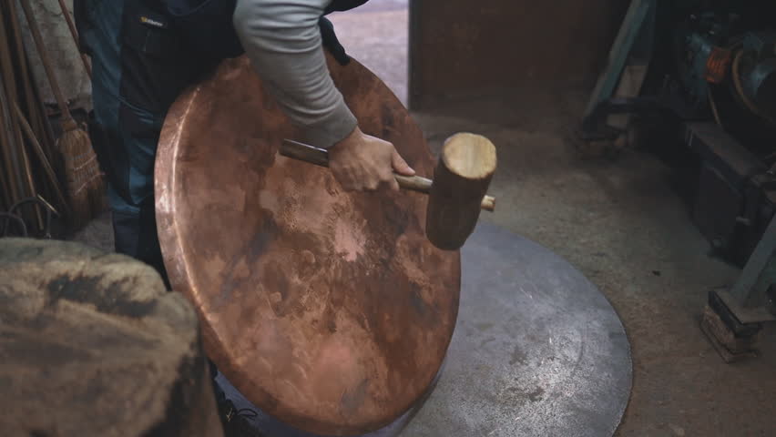Traditional coppersmith workshop for copper brewing pots manufacturing. This handmade brewery kettles will be used for making traditional alcohol brandy drinks. Small traditional business concept.