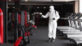 Hazmat worker disinfects gym equipment to prevent COVID-19, highlighting sanitation, hygiene, and public health safety measures. - Powered by Shutterstock - Get 15% off with code: PIKWIZARD15
