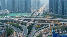 Timelapse aerial view of busy highway overpass intersection with traffic flowing through modern city skyline during twilight hours - Powered by Shutterstock - Get 15% off with code: PIKWIZARD15