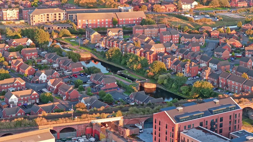 Drone footage of the surrounding neighborhood and housing and canal near Everton FC’s new Bramley-Moore Dock stadium in Liverpool, England. Captured at sunset.