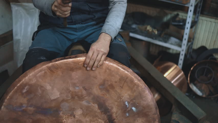 Traditional coppersmith workshop for copper brewing pots manufacturing. This handmade brewery kettles will be used for making traditional alcohol brandy drinks. Small traditional business concept.