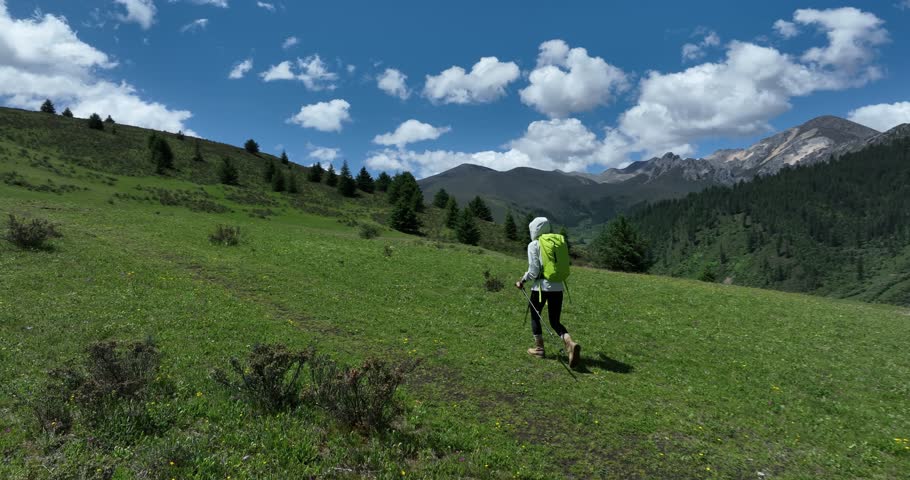 Backpacking woman hiking on grassland mountains top , slow motion 