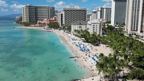 Drone aerial footage of Waikiki Beach in Honolulu, Hawaii, showing turquoise ocean waves, sandy beach, and the iconic line of hotels and resorts along the tropical coastline. - Powered by Shutterstock - Get 15% off with code: PIKWIZARD15