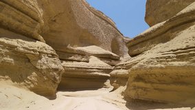 Striking sandstone canyon walls and winding passageways at Canyon of the Lost in Ica Peru under a clear blue sky - aerial flying through - Powered by Shutterstock - Get 15% off with code: PIKWIZARD15