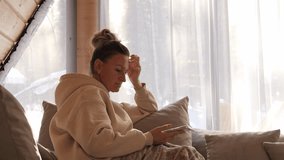  Cozy home interior woman sits on sofa with blanket enjoying digital connection Relaxed phone conversation highlights comfort calm lifestyle and conversation adds warmth conversation builds harmony - Powered by Shutterstock - Get 15% off with code: PIKWIZARD15