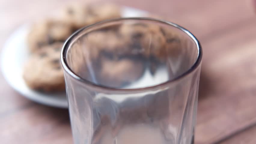 Chocolate Milk Being Poured into a Glass with Cookies 4k video