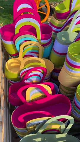 Close-up of bright multicolored plastic baskets in a rustic wooden crate at a local market. Cinematic autumn fair scene, vibrant seasonal shopping display, festive marketplace atmosphere