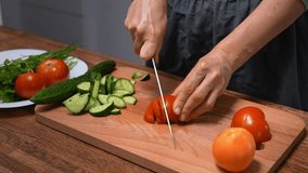 Woman chopping vegetables for salad, cucumbers and tomatoes. Close-up, fresh ingredients. - Powered by Shutterstock - Get 15% off with code: PIKWIZARD15