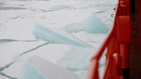 Orange ship railing alongside fractured sea ice as a vessel navigates frozen waters, breaking through pack ice floes during a maritime expedition in a remote polar environment - Powered by Shutterstock - Get 15% off with code: PIKWIZARD15