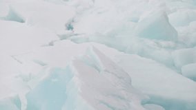 Fractured polar sea ice with blue-tinted slabs and ridges, showcasing frozen textures, jagged cracks, and minimalist patterns across a cold ocean surface in winter light. - Powered by Shutterstock - Get 15% off with code: PIKWIZARD15