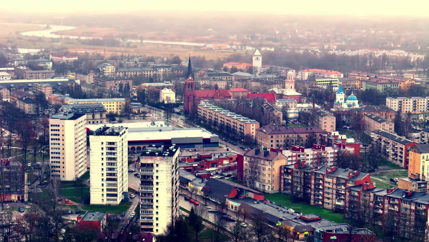 Aerial view of urban landscape at sunrise, with vibrant city life