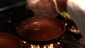 A chef cooking chicken strips in a copper frying pan over a gas stove with flames. - Powered by Shutterstock - Get 15% off with code: PIKWIZARD15