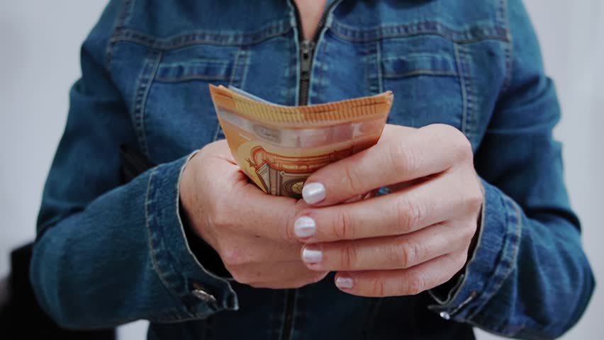 Woman's hands counting euro banknotes and holding them out for payment. Successful business deal, cost control, debt repayment, lending, loan, corruption, bribe close up