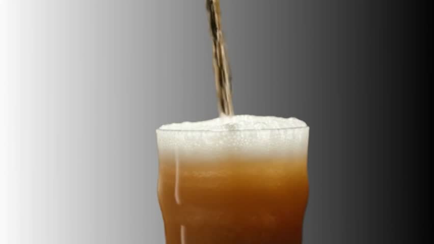 beer being poured into a glass, producing foam on top