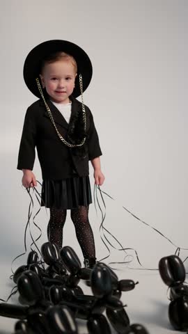 Little girl holding balloons. Stylish child concept.