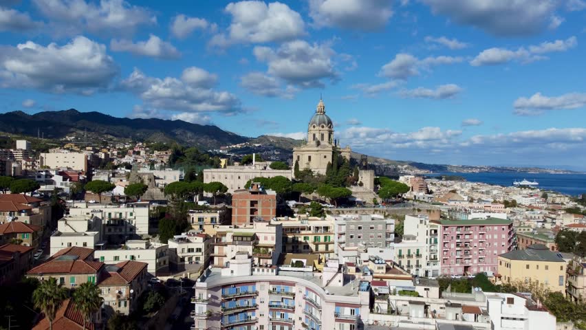 Drone footage of Messina, Sicily, Italy. Captured on a sunny day with a few clouds, showing aerial views of the historic city center, coastline, harbor, and beautiful Mediterranean landscape.