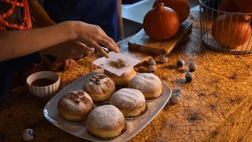 Happy mother and children in festive costumes decorate homemade Halloween donuts in the kitchen, with eye-shaped candies lying on the table nearby, enjoying spooky and fun holiday tradition together. - Powered by Shutterstock - Get 15% off with code: PIKWIZARD15