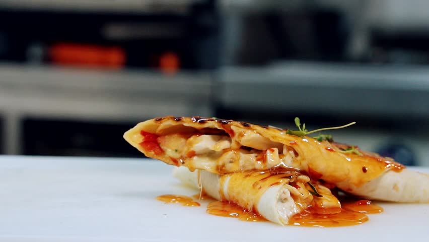 Delicious appetizer decorating with green. Chef's hand strewing pita by green sprouts before serving in the restaurant. Close-up. Slow motion.