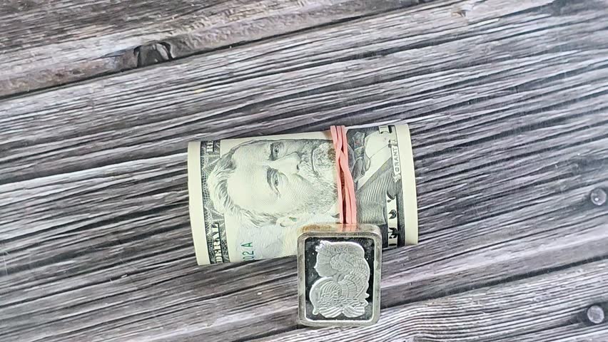 pure fine silver Ounce 1 OZ and 50 USD fifty American dollars banknotes cash money bills rolled up with a rubber band, features Ulysses S. Grant, American money and silver price concept