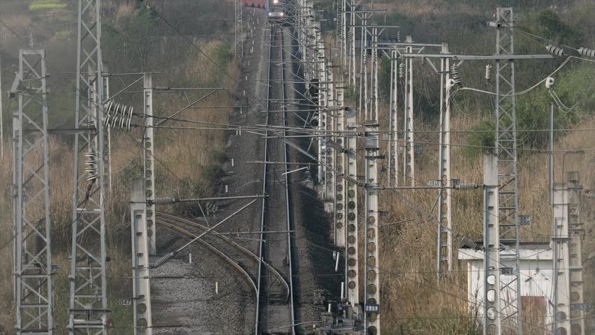 Aerial view of railway infrastructure with multiple train tracks, electrical power lines, and switching systems for freight and passenger rail transport