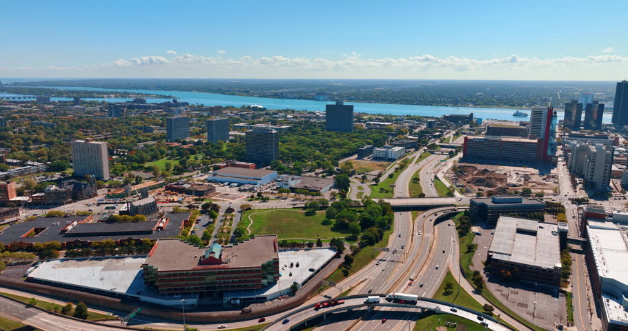 View on the branched multi-lane roads crossing the cityscape. Green panorama of Detroit, Michigan, USA on sunny day. Aerial perspective.