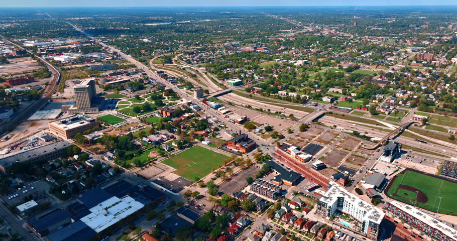 Approaching the branched roads with bridges above. Lush green cityscape of Detroit, Michigan, USA. Aerial view.