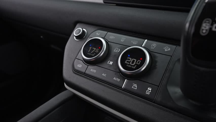 hand using the climate control system in a modern car, adjusting temperature and airflow through a sleek, digital dashboard for maximum comfort and convenience while driving